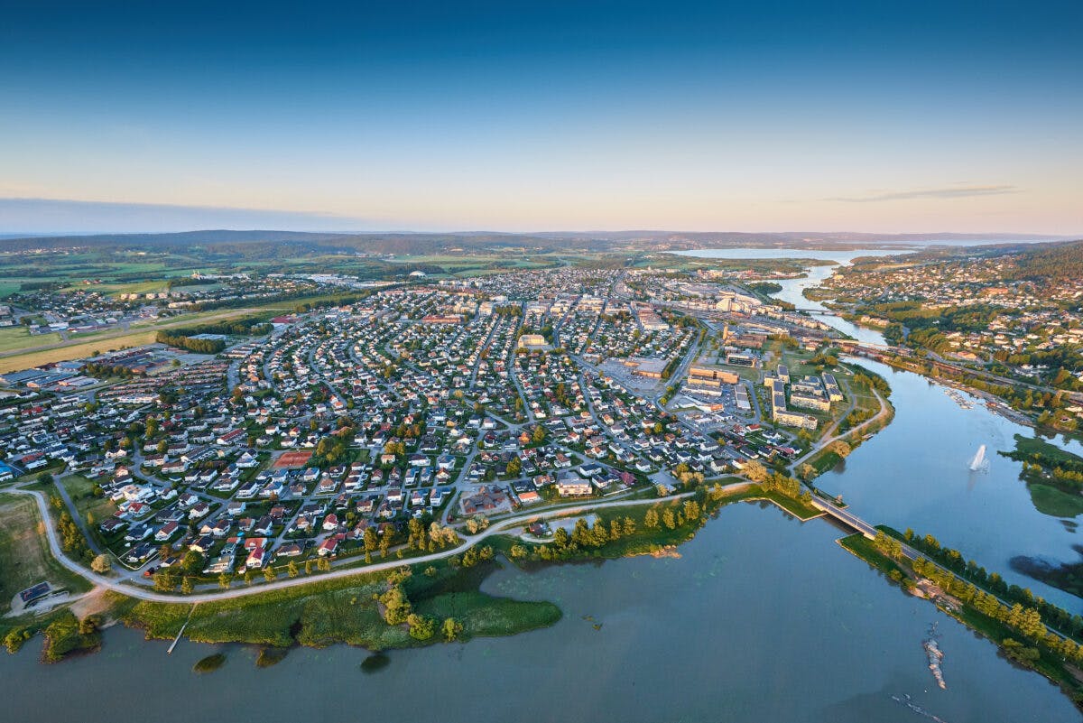 Luftfoto av et forstadsområde nær en elv i skumringen.